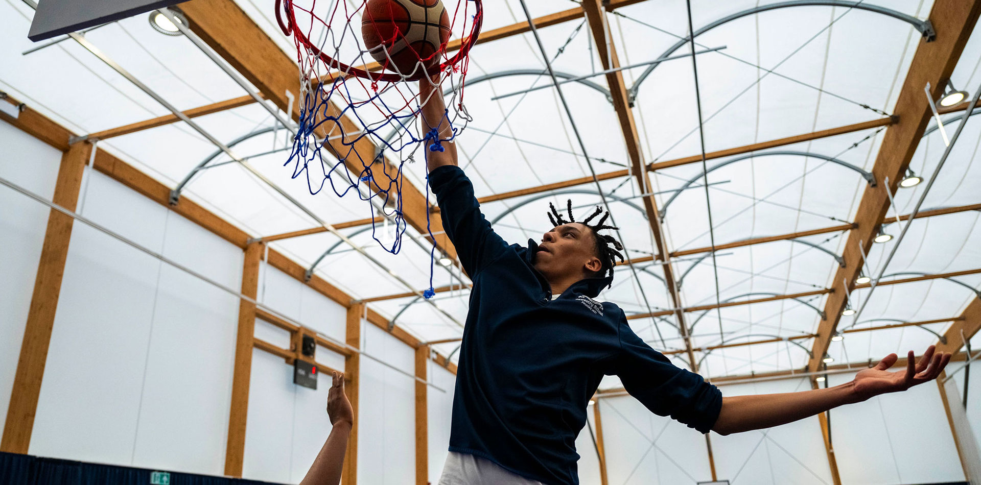Student at Oswestry School playing basketball in the sports facilities.